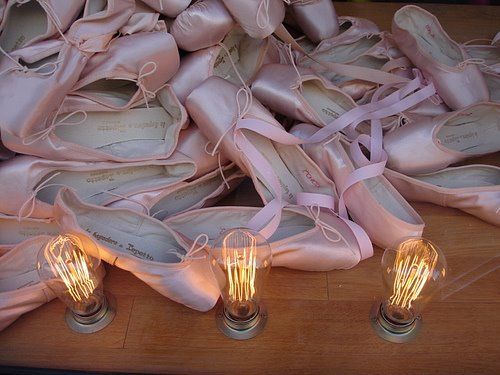 several pairs of ballet shoes with light bulbs on them sitting on a table next to each other