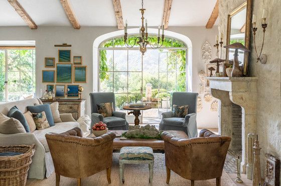 a living room with couches, chairs and a fire place in front of a fireplace