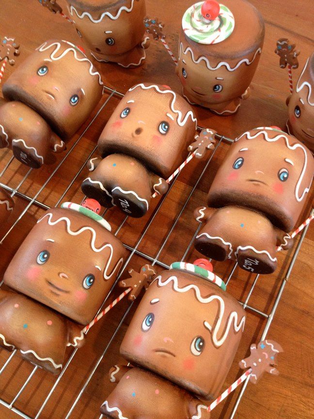 several gingerbreads with icing and decorations on a cooling rack