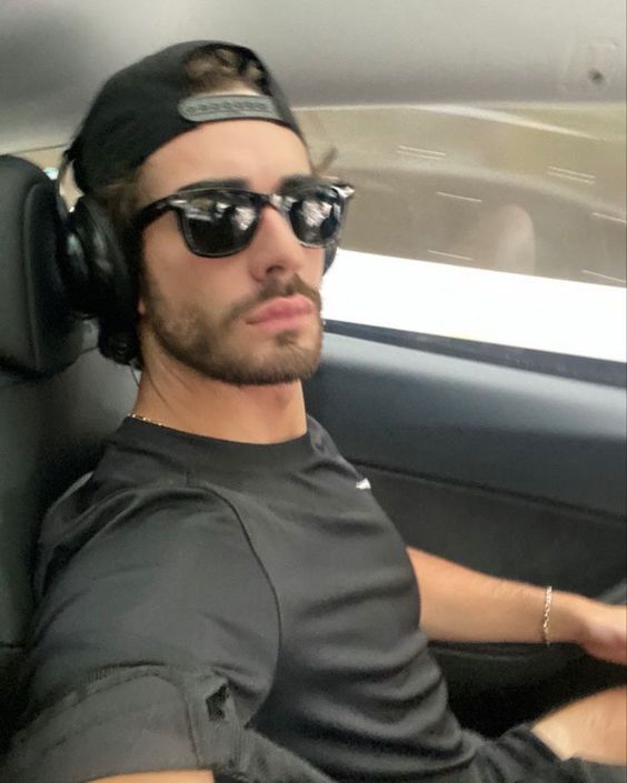 a man wearing headphones sitting in the back seat of a car