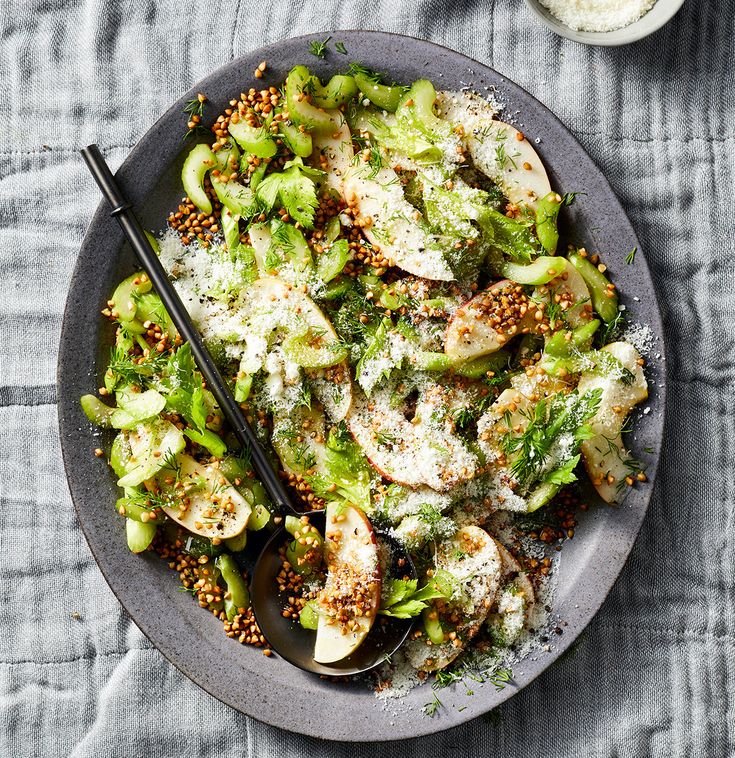 a bowl filled with broccoli and other food on top of a blue table cloth