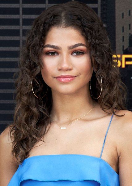 a close up of a person wearing a blue dress and large hoop earrings on her head