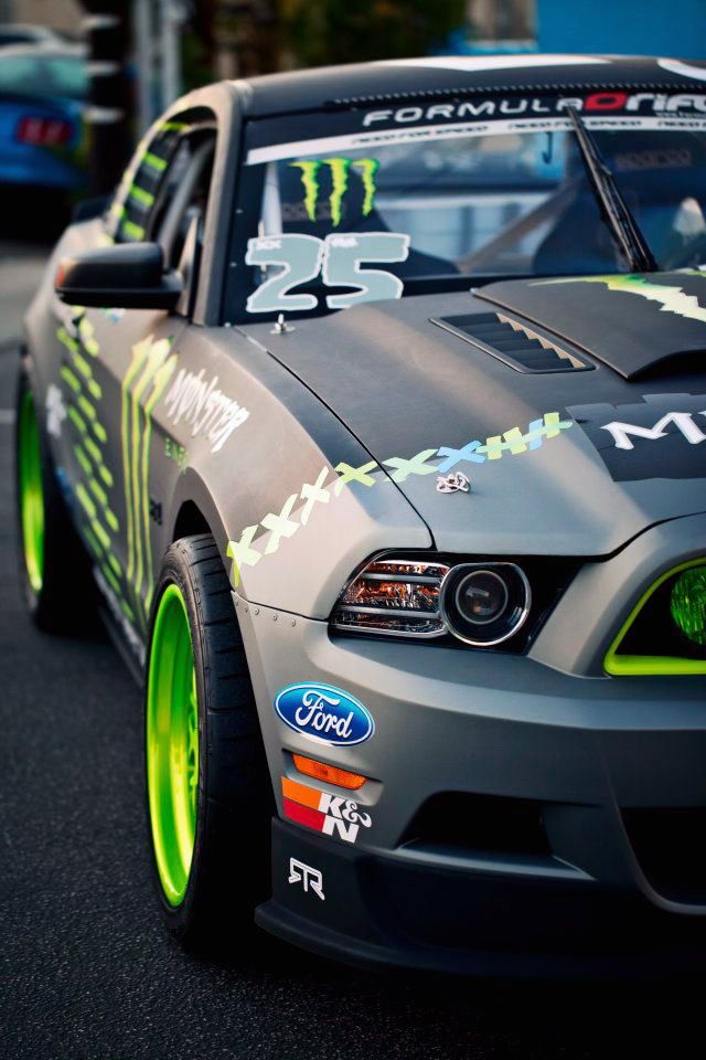 the front end of a gray mustang car with monster stickers on it