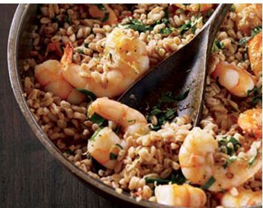 shrimp and rice in a skillet with tongs