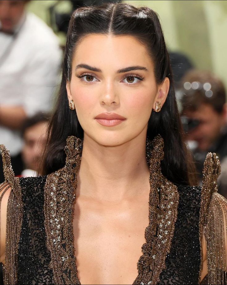 a close up of a person with long hair and earrings on her head, wearing a black dress