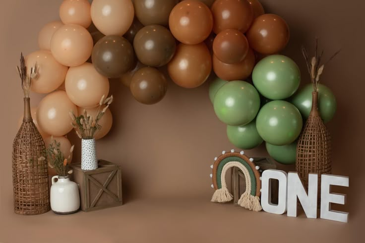 some balloons are hanging on the wall and one is in front of a sign that says one