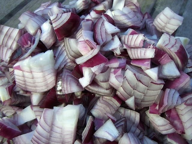 chopped red onions sitting on top of a wooden table