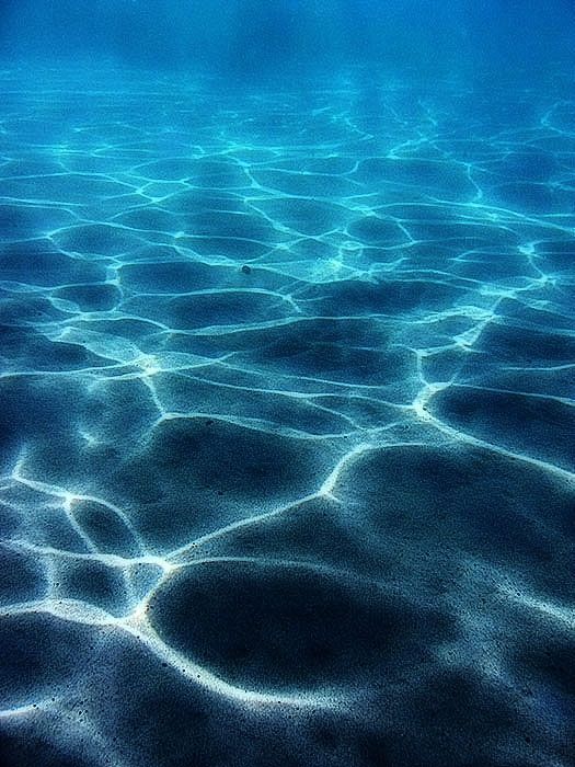 the water is very clear and blue with some small bubbles in it's surface