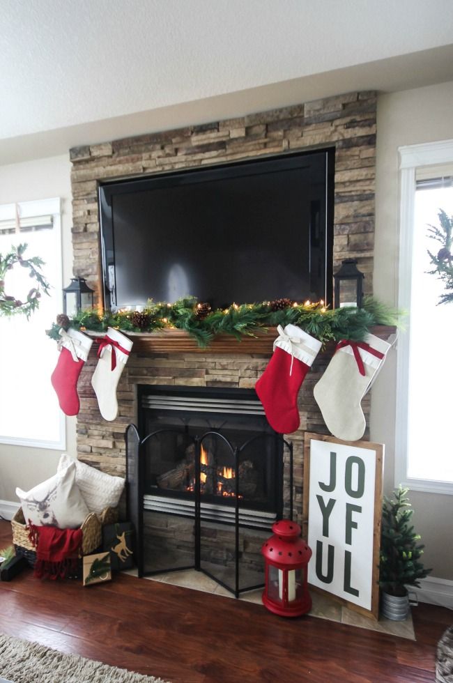 a living room decorated for christmas with stockings, stockings and stockings on the fireplace mantel