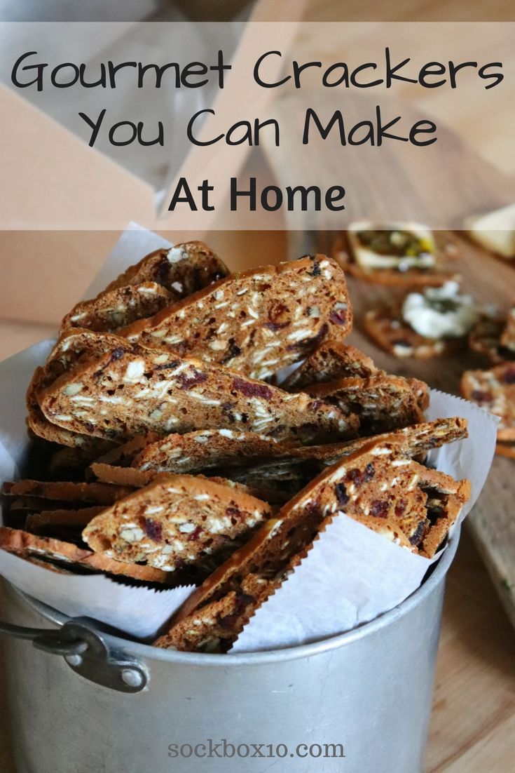 some crackers are in a metal bucket on a table with the words, gourmet crackers you can make at home