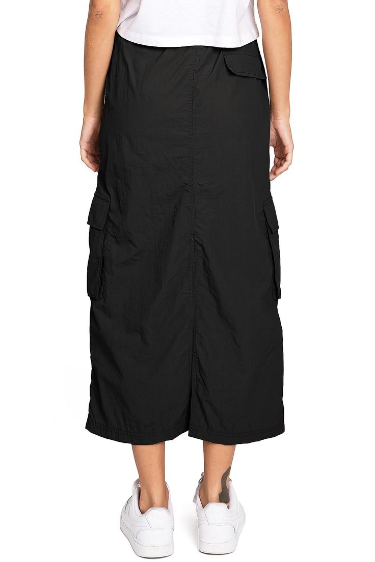 Chic, parachute skirt with an elastic waistband, a drawstring cinch tie and cargo pockets down the sides. Pair it with a graphic tee and sneakers for an effortless streetwear look. CARE | Machine Wash Cold CONTENTS | 100% Nylon MEASUREMENTS | 33"/85 cm Top to Bottom (Size Small) MODEL | 5'8 - wearing a size Small IMPORTED Utility Cargo Skirt With Elastic Waistband, Spring Nylon Cargo Skirt With Pockets, Black Utility Parachute Pants For Summer, Spring Cargo Skirt With Pockets For Streetwear, Black Casual Cargo Skirt For Streetwear, Spring Streetwear Cargo Skirt With Pockets, Summer Utility Cargo Skirt With Drawstring, Casual Relaxed Cargo Skirt With Side Pockets, Casual Cargo Skirt With Side Pockets