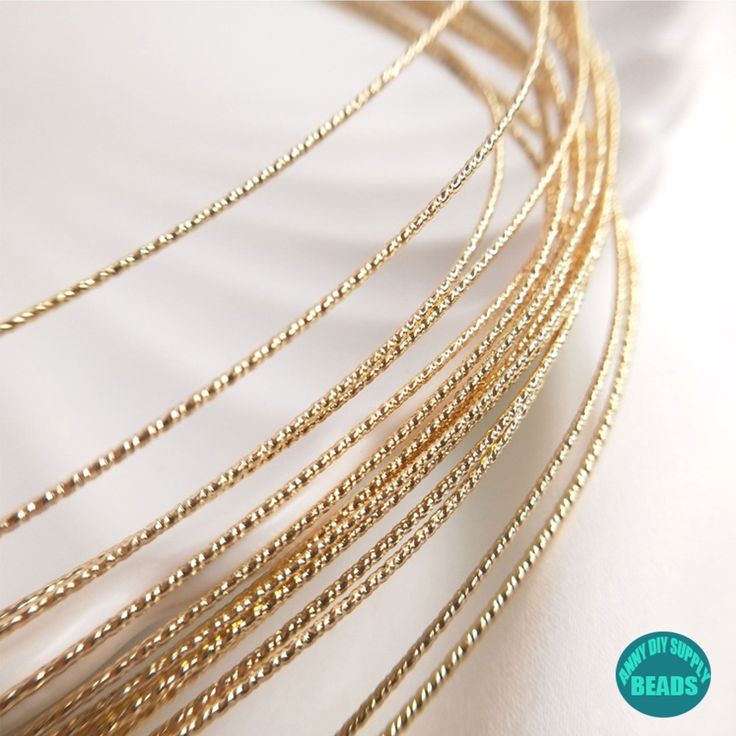 several gold necklaces on a white surface