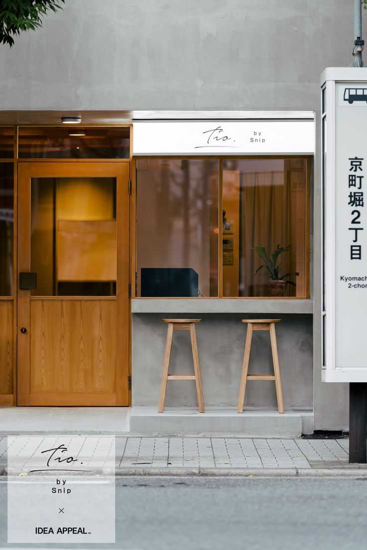 two wooden stools sitting outside of a building next to a sign that says koba appel