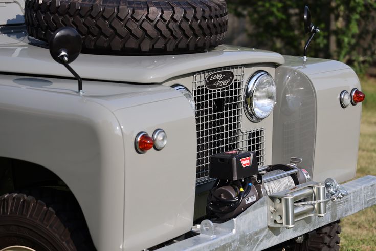 the front end of an old grey jeep