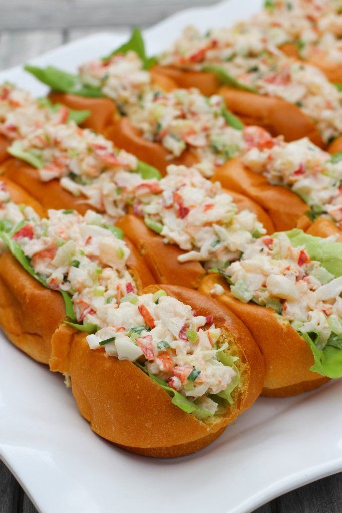 a white plate topped with hot dogs covered in coleslaw and lettuce