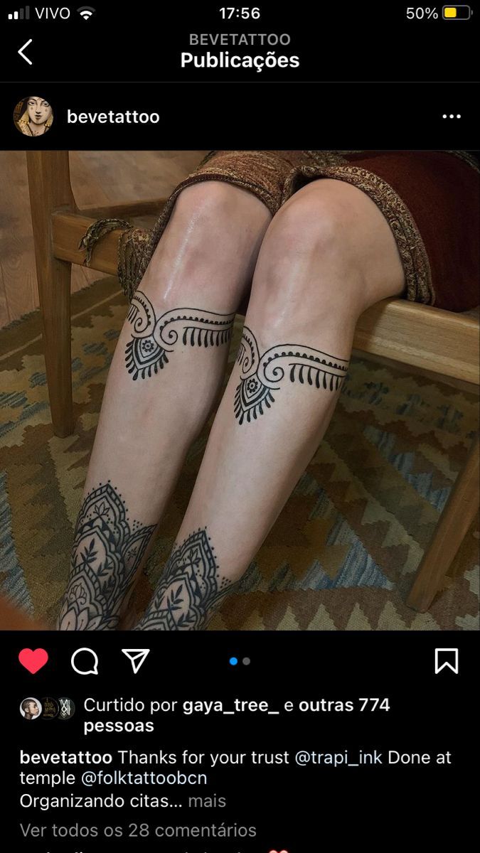 a woman with tattoos on her legs sitting in a chair