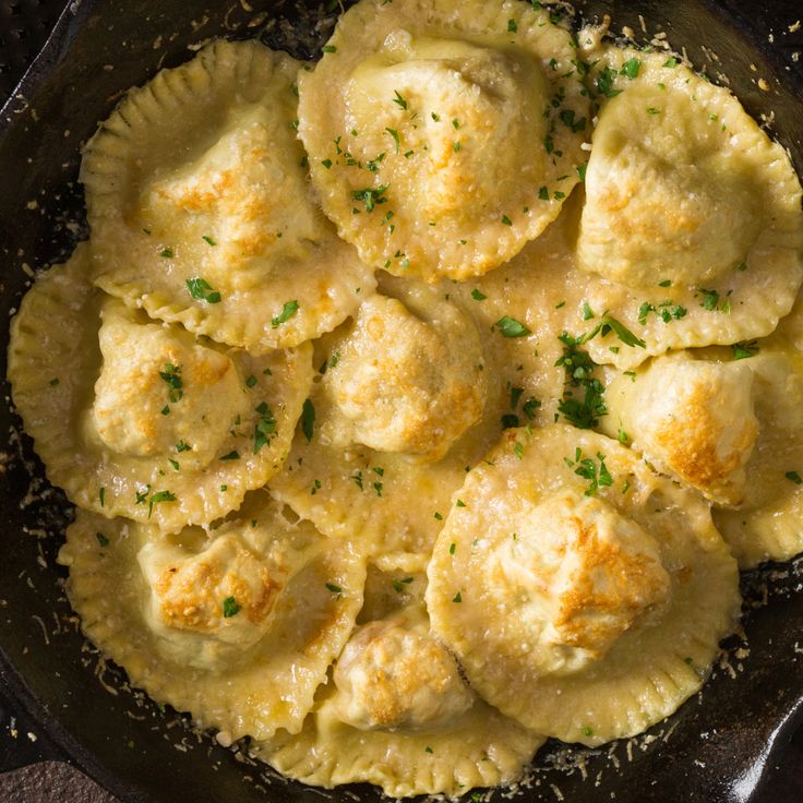 a skillet filled with dumplings covered in cheese