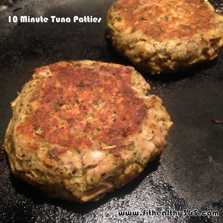 two hamburger patties sitting on top of a black grilling pan next to each other