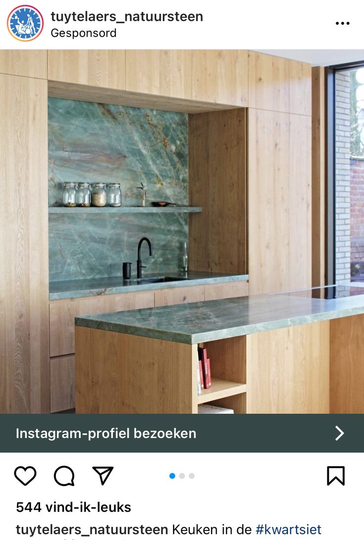 a kitchen with wooden cabinets and green marble counter tops, along with an open window