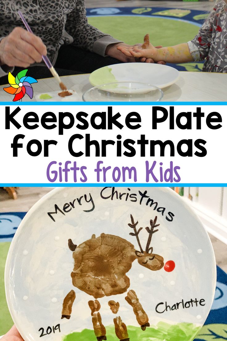 two children are sitting at a table and one is holding a plate with a reindeer on it