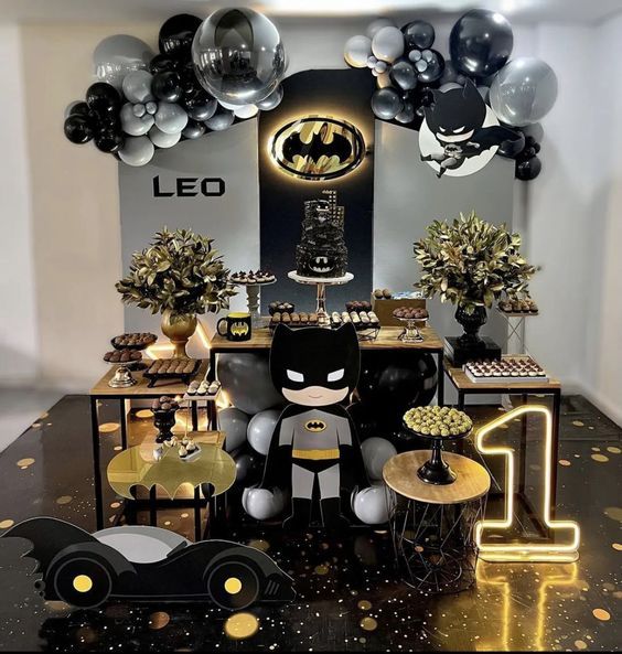 a batman themed birthday party with balloons, decorations and decorating on the table in front of it