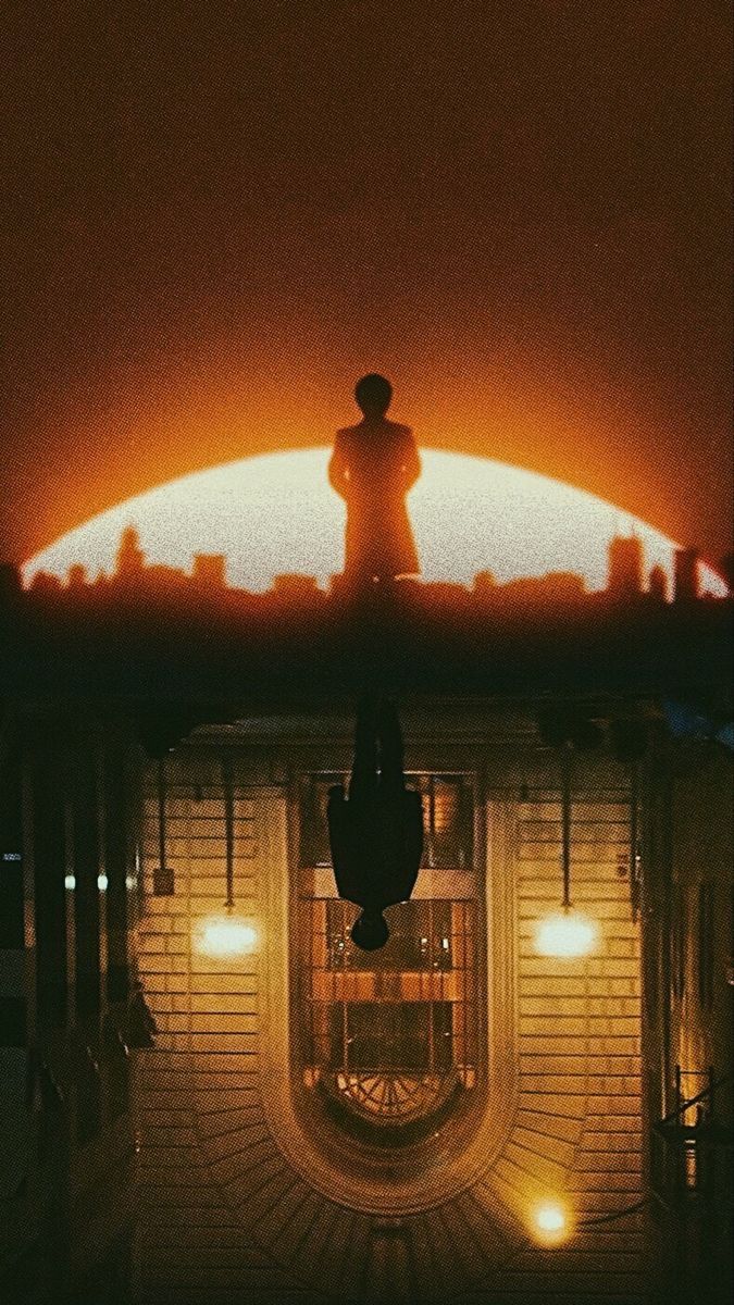 a man standing on top of a roof in front of a building with a clock