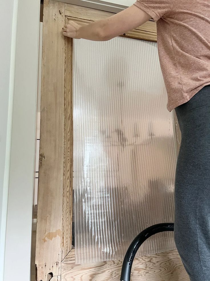 a woman is opening the door with her hand and holding it in place to open