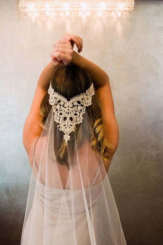 a woman wearing a veil and holding her hair in front of the camera with one hand