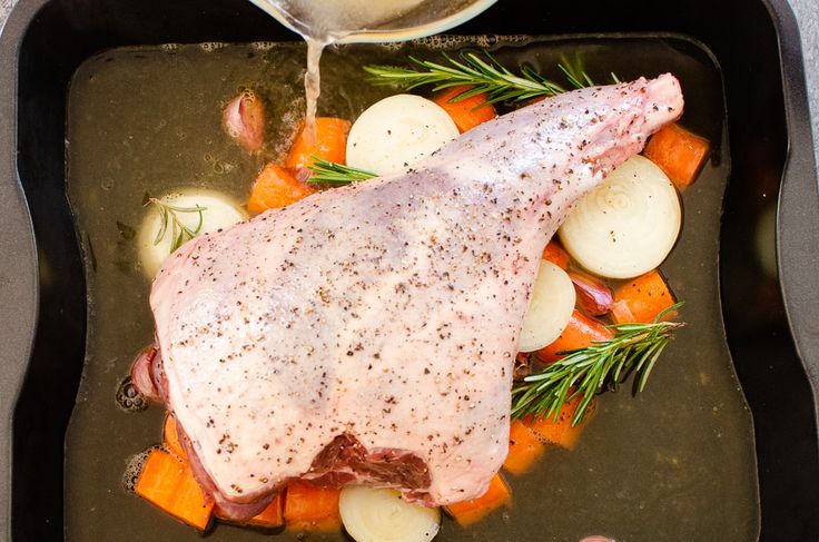 a roasting pan with meat, potatoes and carrots