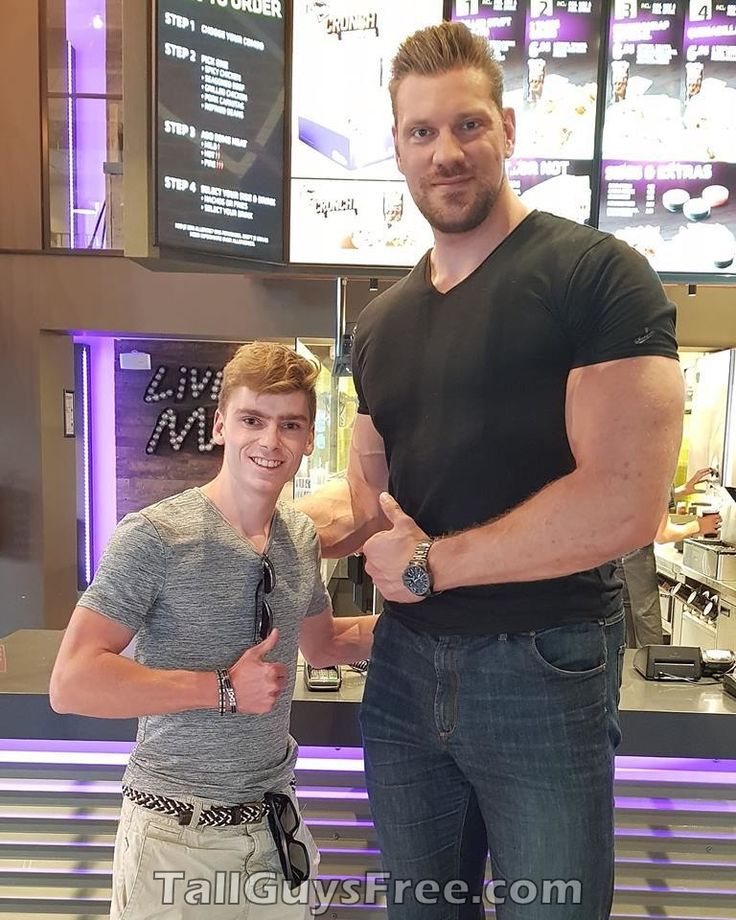 two men standing next to each other in front of a counter