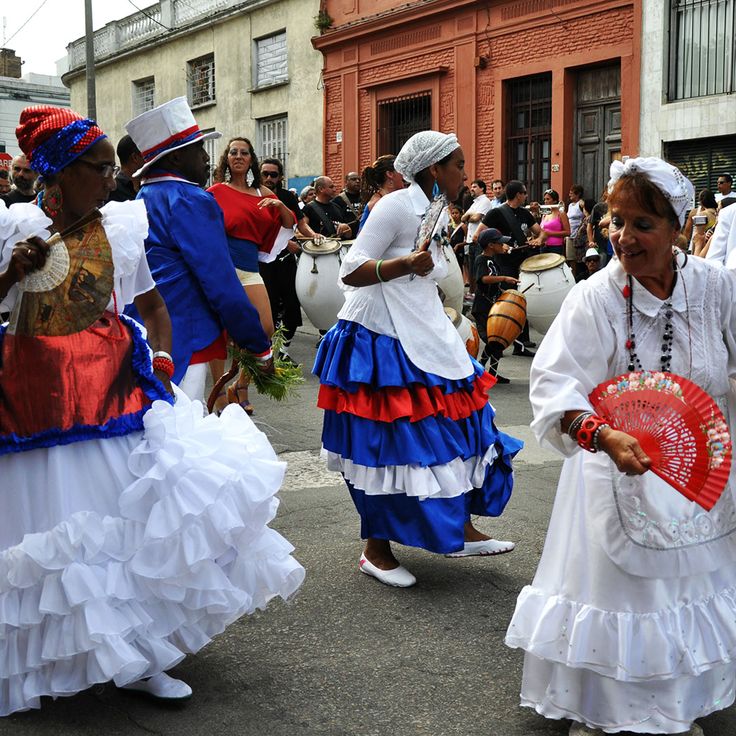 women in colorful dresses are dancing on the street