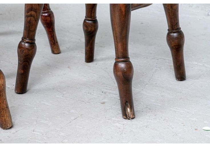 two wooden stools sitting next to each other on a white carpeted room floor