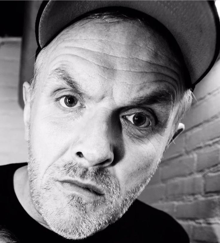 black and white photo of a man wearing a hat looking at the camera with an intense look on his face