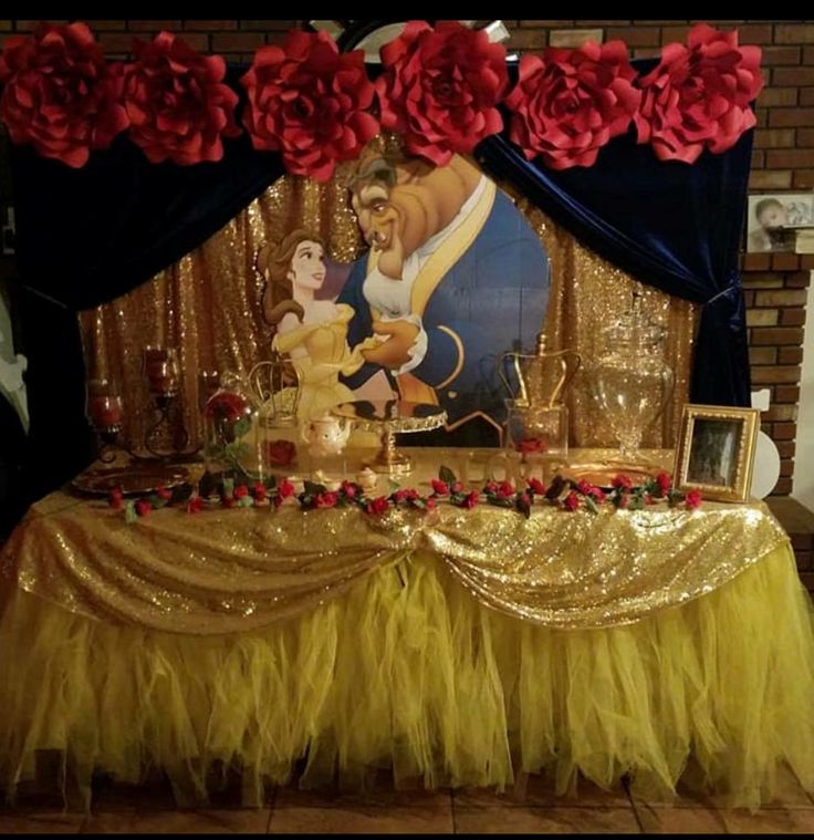 the beauty and the beast table is set up for a party with red roses on it