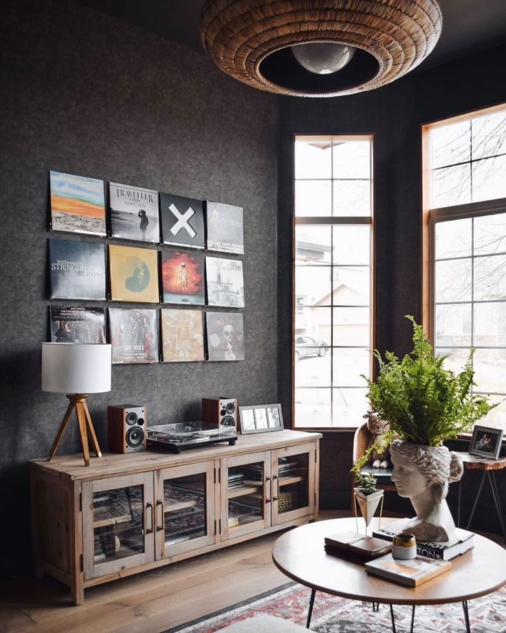 a living room filled with furniture and lots of windows next to a wall covered in pictures