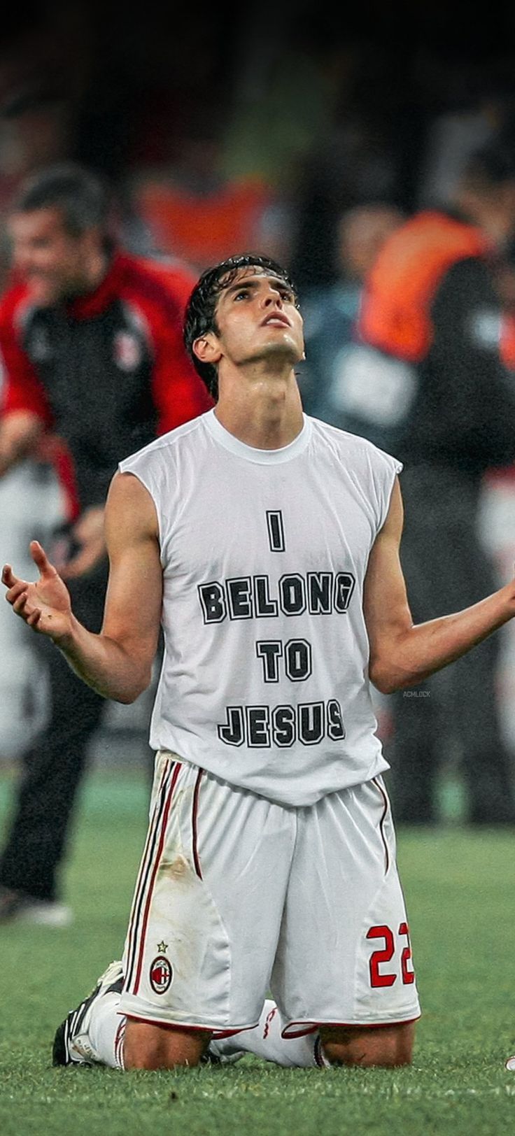 a man standing on top of a soccer field holding his hands up in the air