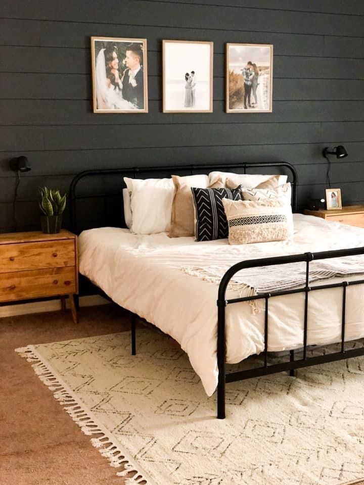 a bed sitting in a bedroom next to two framed pictures on the wall above it