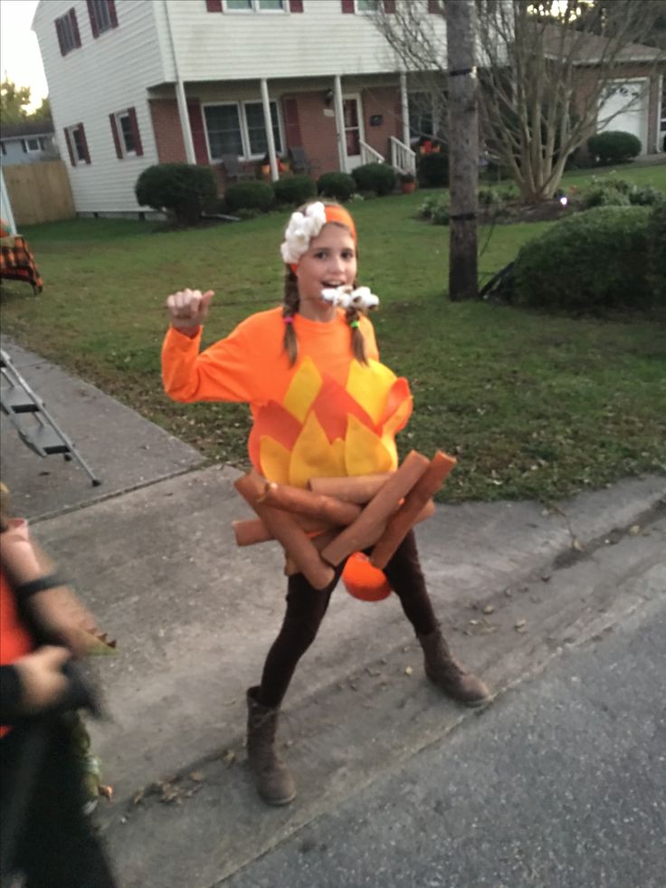 a woman in an orange and yellow costume walking down the street