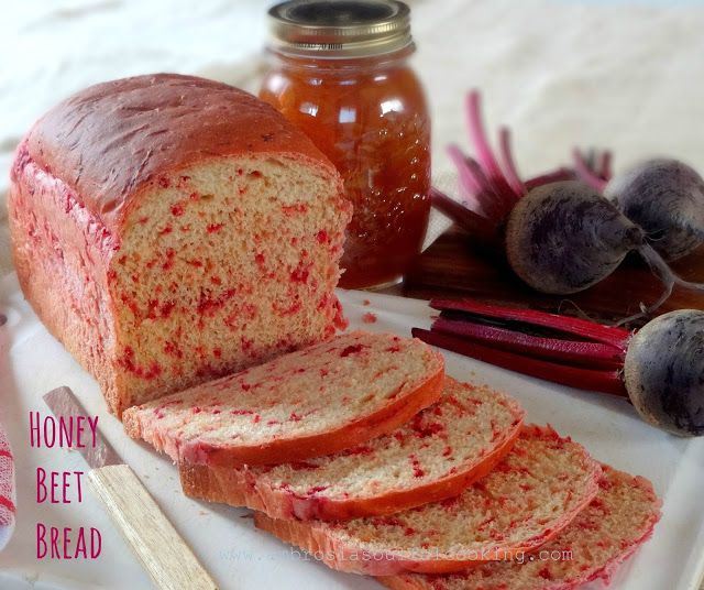 sliced loaf of honey beet bread sitting on a cutting board next to other items