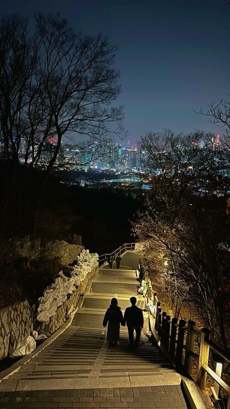 two people are walking down the stairs at night