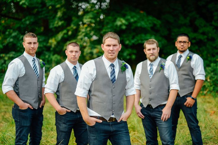 a group of men standing next to each other on top of a grass covered field