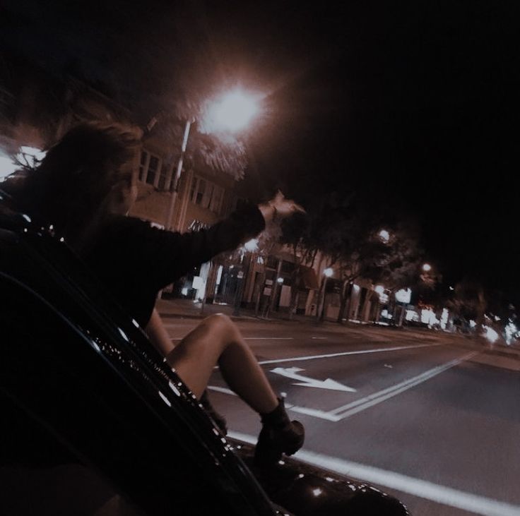 a person sitting in the passenger seat of a car at night