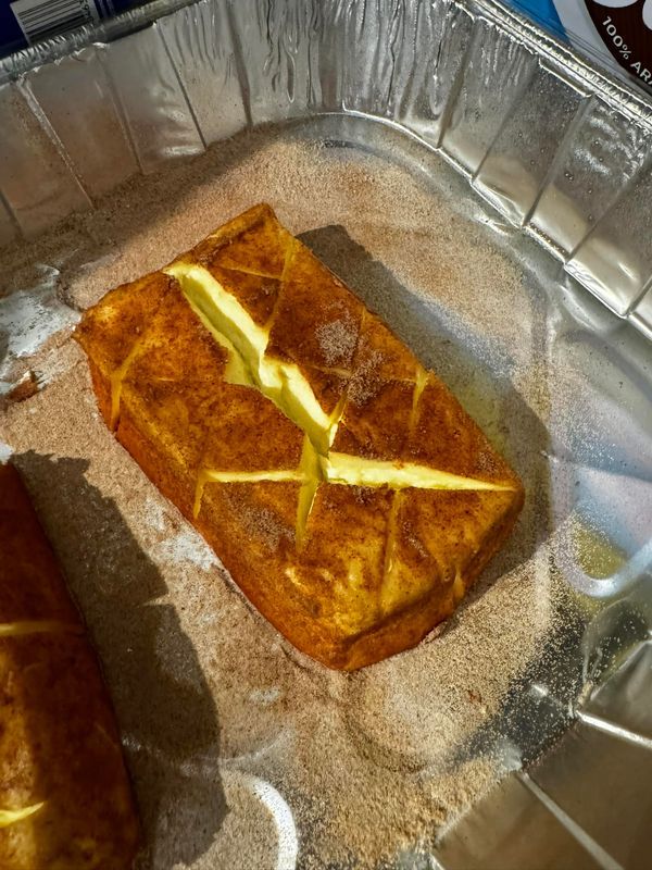 two pieces of bread sitting on top of a pan covered in tin foil next to each other