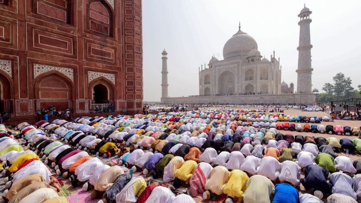 a large group of people standing in front of a building with many headscarves