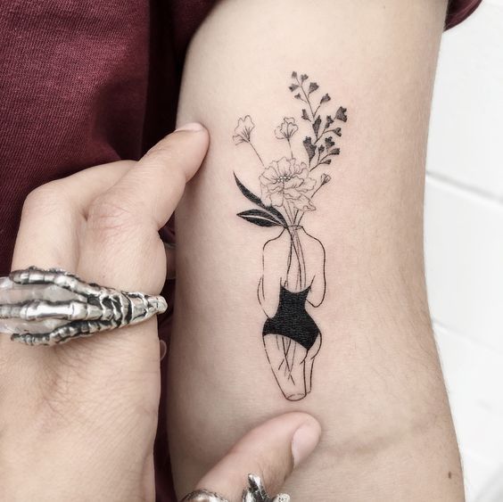 a woman's arm with a flower tattoo on the left side of her body