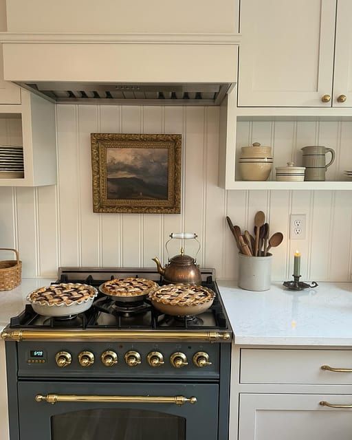 a stove top oven sitting inside of a kitchen next to white cupboards and counter tops