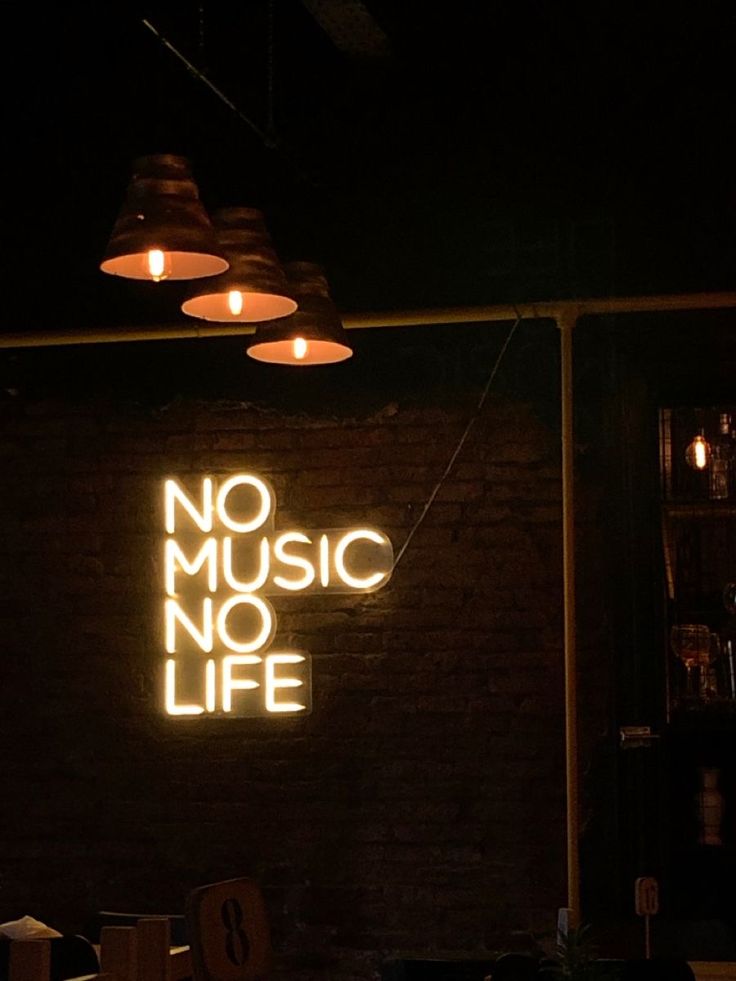 there is a neon sign that says no music no life on the wall behind it