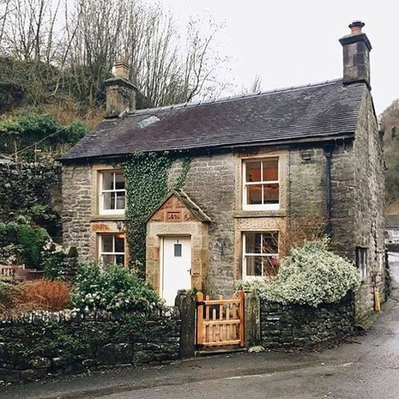 an old stone house with ivy growing all over it