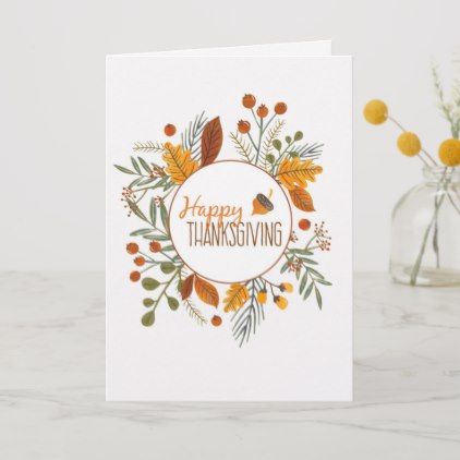 a card with the words happy thanksgiving written in orange and green leaves on it next to a vase filled with flowers