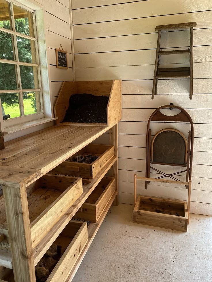 the inside of a small wooden cabin with shelves and drawers in front of a window